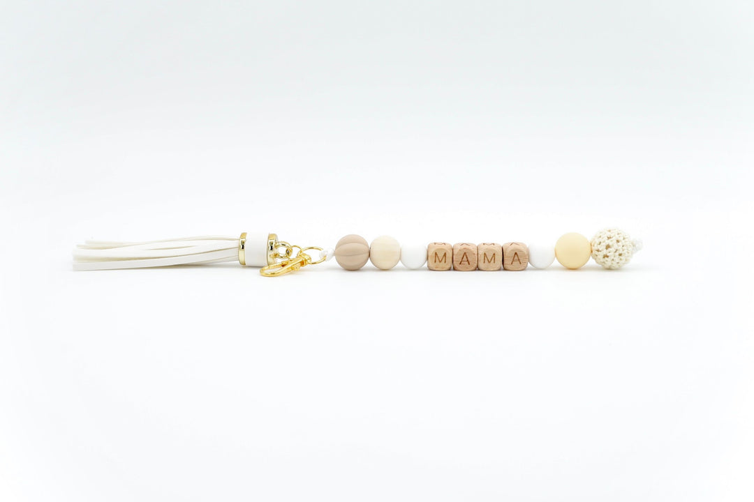 Neutral-toned bag charm for mum with tassel and wooden MAMA letter beads on white background