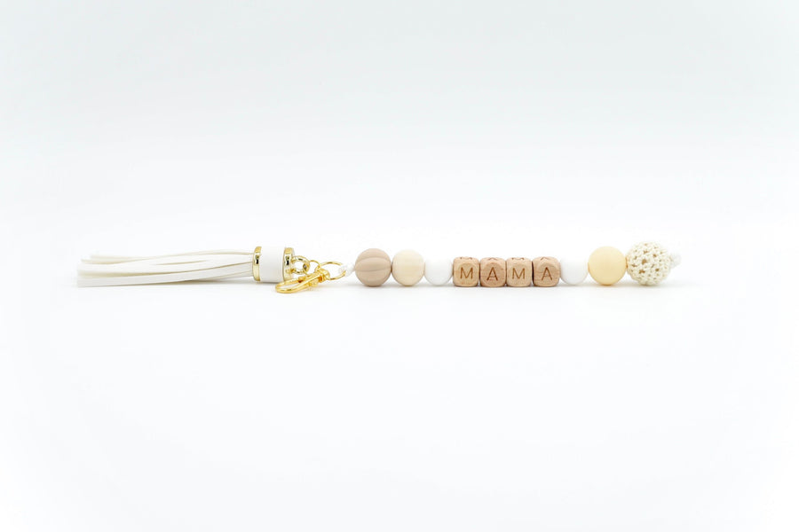Neutral-toned bag charm for mum with tassel and wooden MAMA letter beads on white background