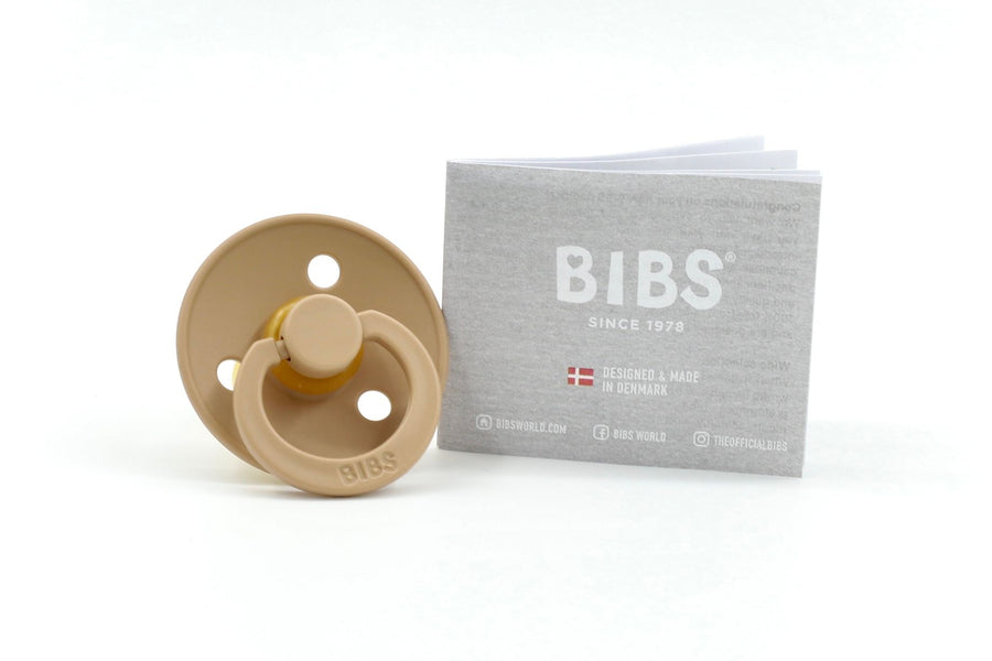 BIBS Colour dummy in Taupe with round natural rubber teat, shown beside grey branded packaging on a white background