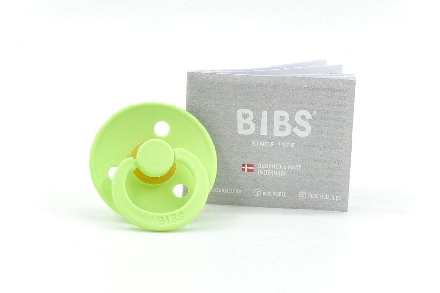 BIBS Colour dummy in Matcha green with round natural rubber teat, displayed with branded grey leaflet on white background