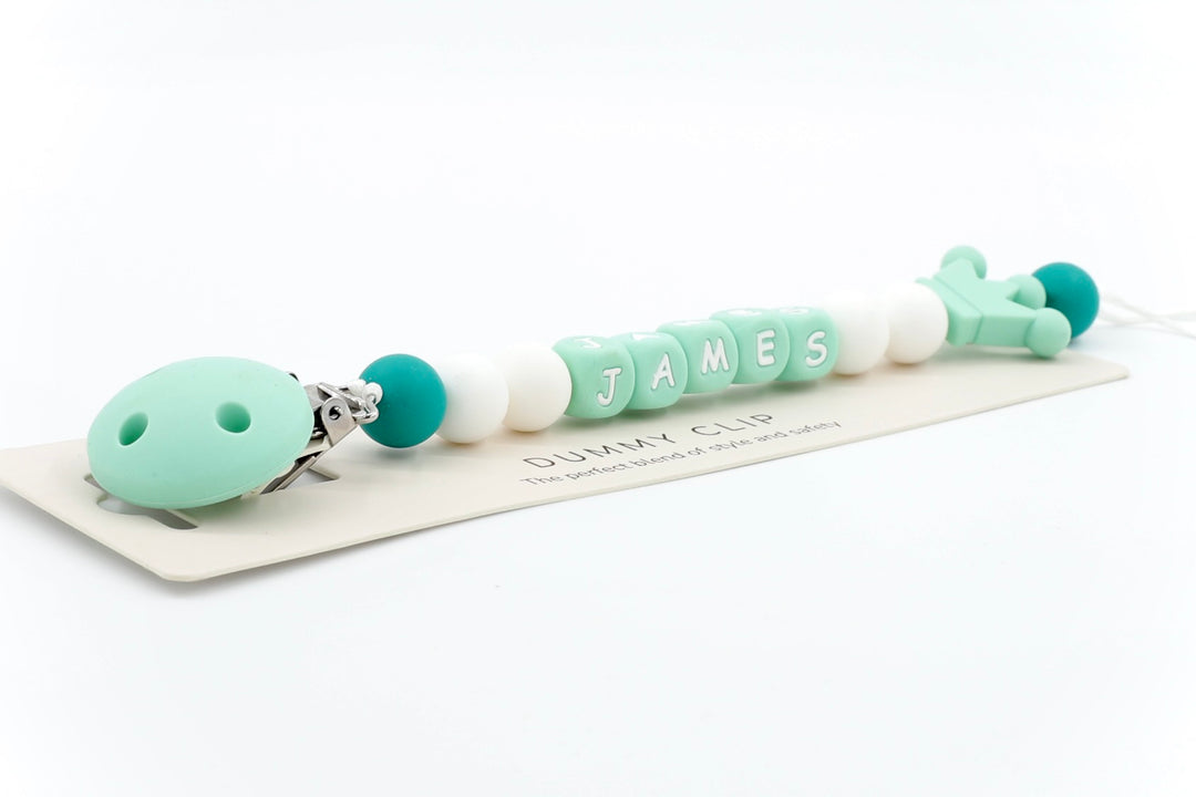 Mono-Crown personalised pacifier clip in mint green and white with name JAMES and crown-shaped end bead