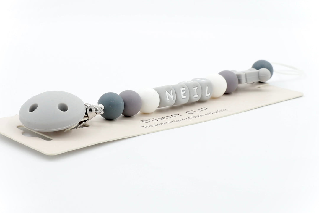 Mono-Crown pacifier clip in grey and white tones with custom name NEIL and matching crown detail