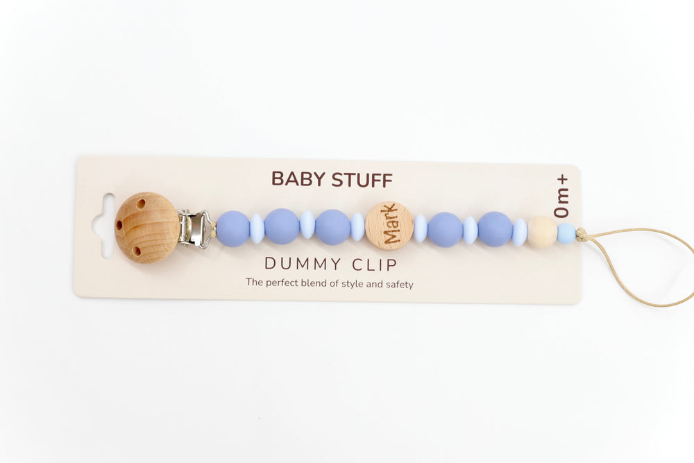 Top down shot of a twilight & baby blue personalised dummy clip with name ‘Mark’ engraved on wooden bead, made from soft silicone and safe for newborn use.