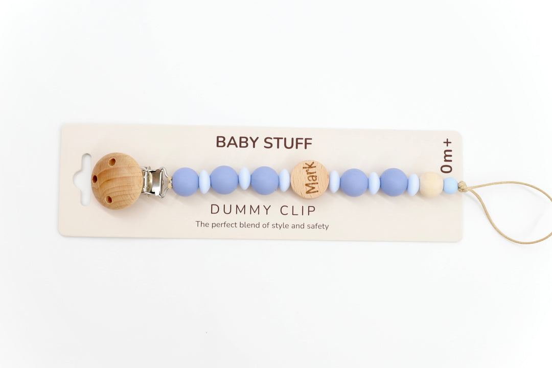 Top down shot of a twilight & baby blue personalised dummy clip with name ‘Mark’ engraved on wooden bead, made from soft silicone and safe for newborn use.