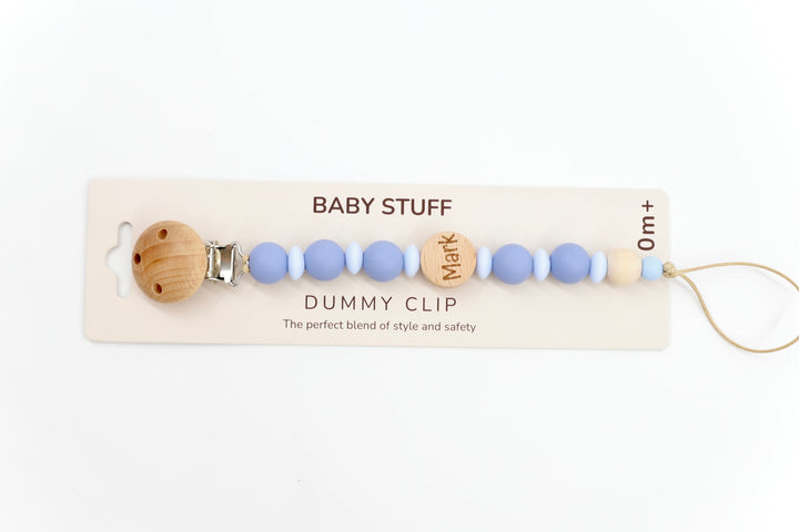 Top down shot of a twilight & baby blue personalised dummy clip with name ‘Mark’ engraved on wooden bead, made from soft silicone and safe for newborn use.