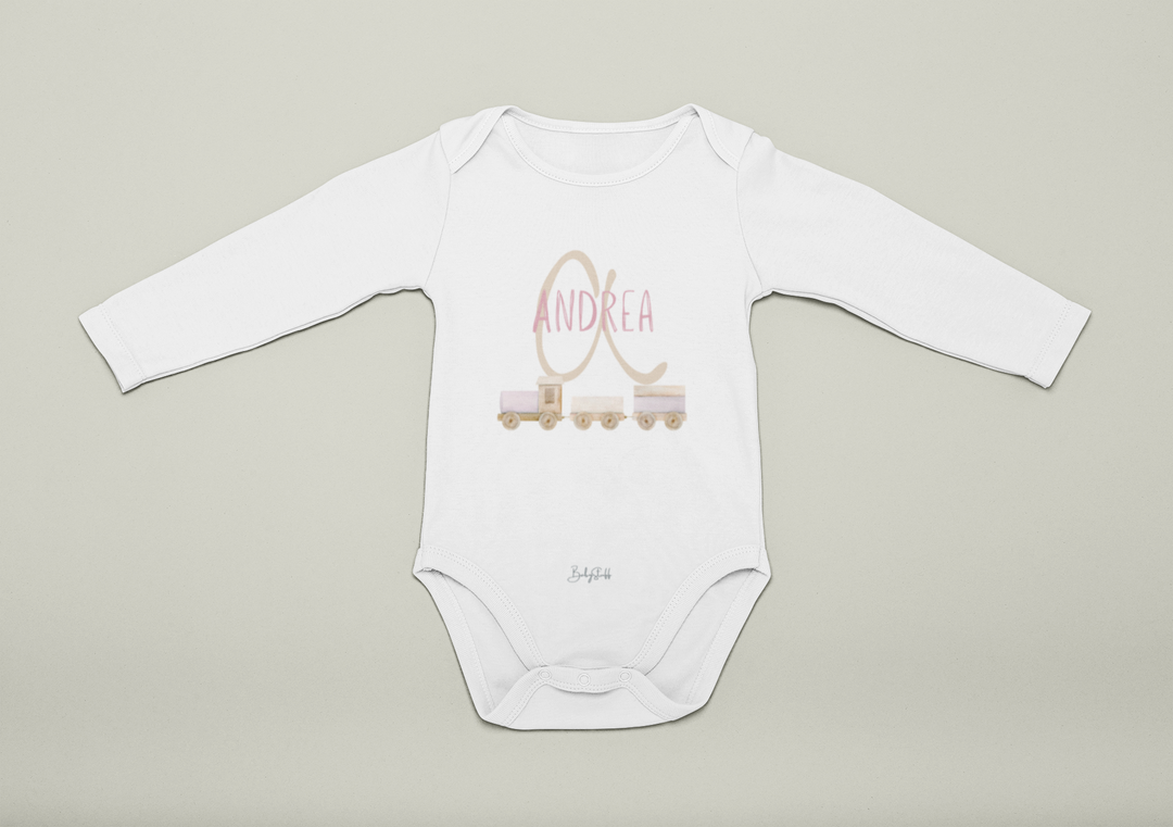 White baby onesie with pink 'Andrea' printed on it against a beige background